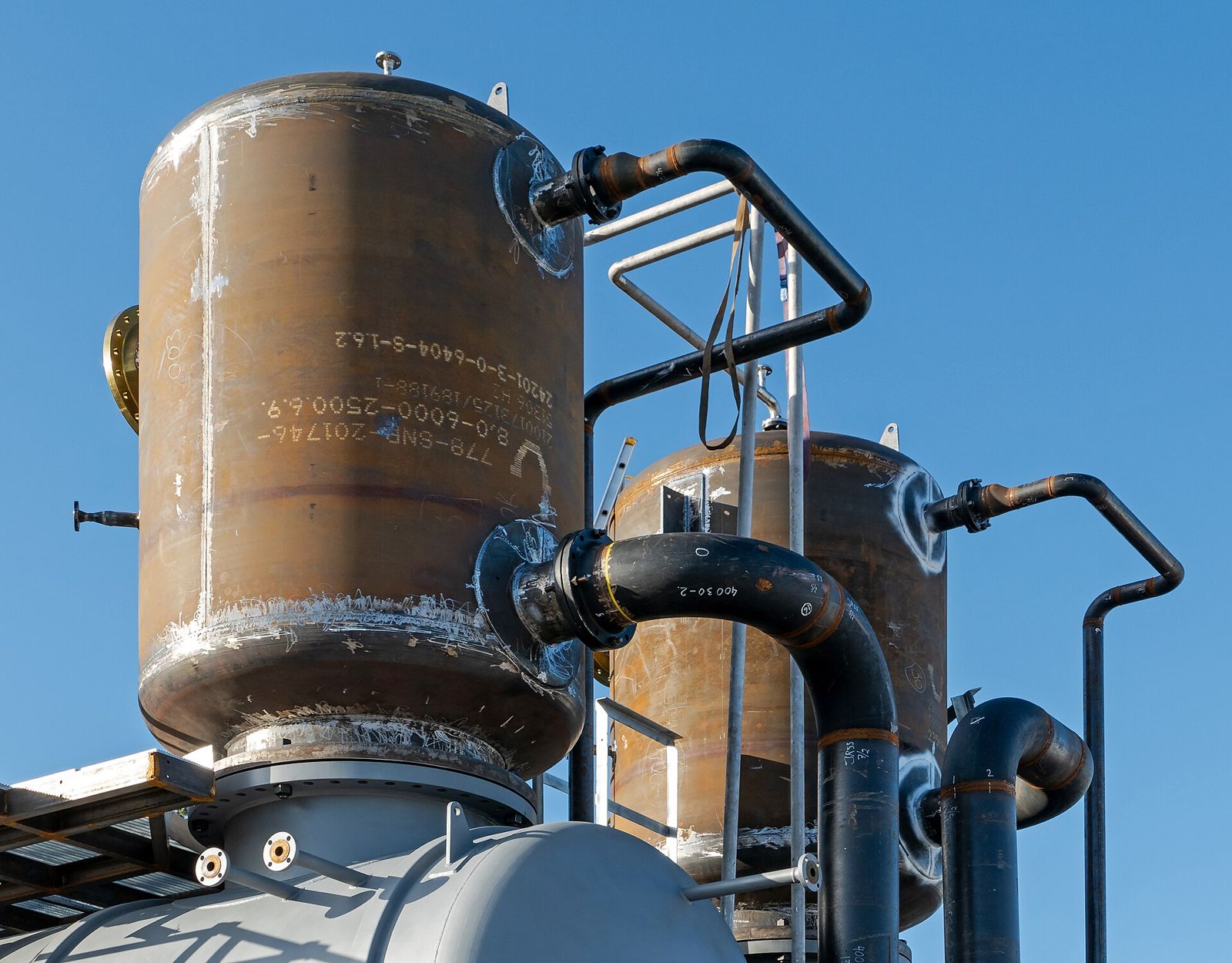 Steel pressure vessels with ladders and piping under fabrication